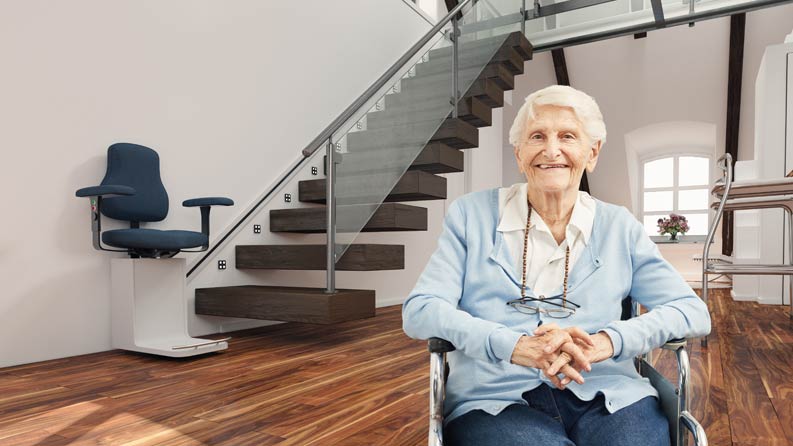 Ältere Dame aus Bayern ist glücklich mit Treppenlift
