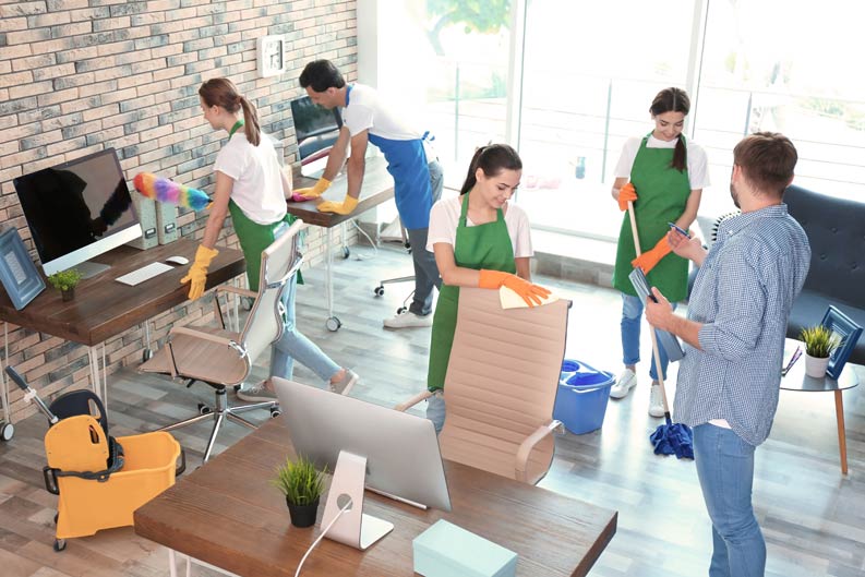 Ganze Truppe reinigt fleißig ein Büro