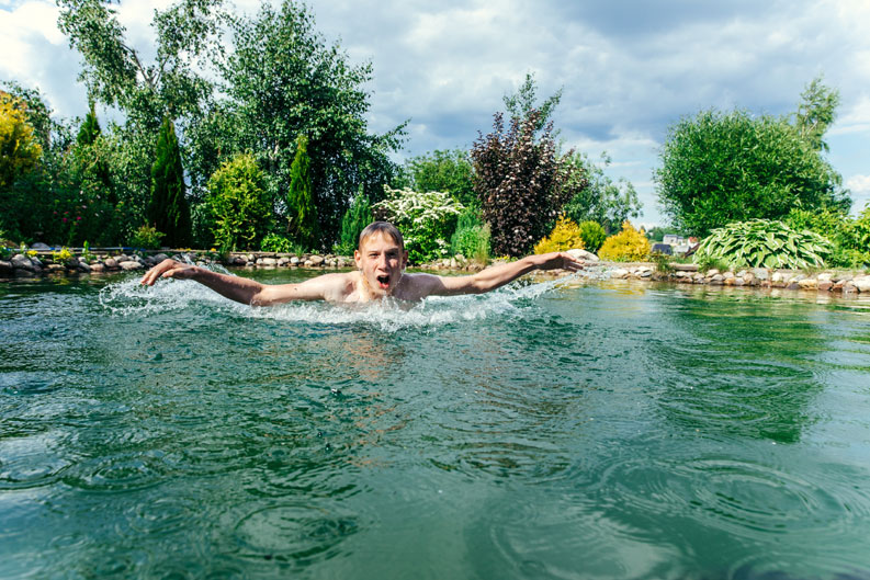 Junger Mann in einem Naturpool