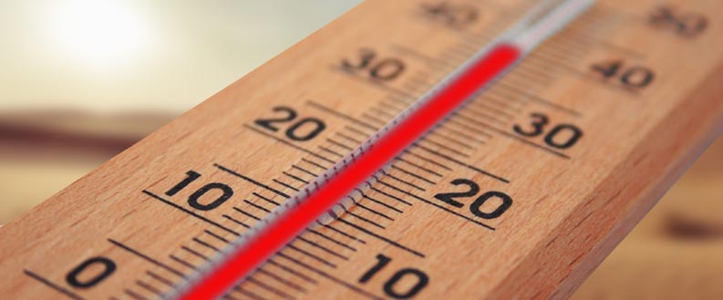Thermometer zeigt warme Temperaturen durch Infrarotheizkörper